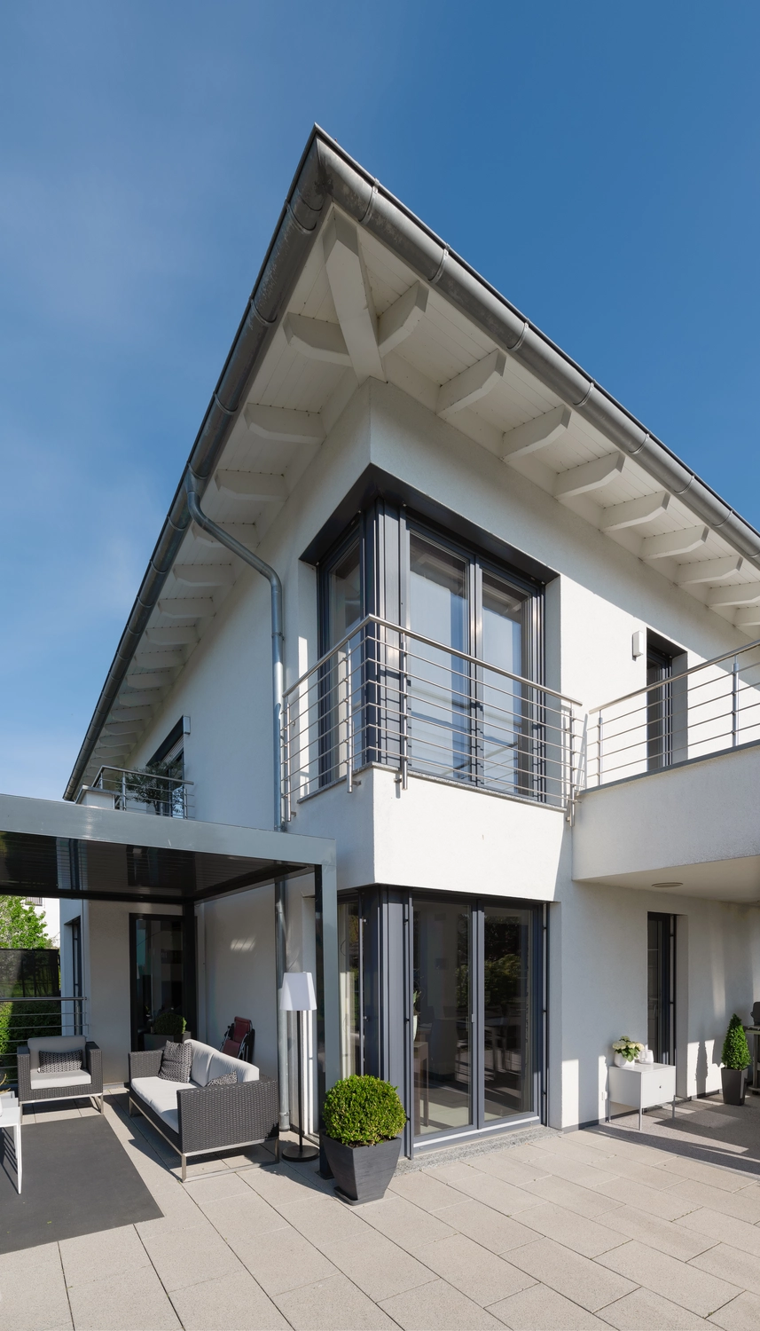 Montage Mündlein – Bauen und Renovieren – Einseitig geöffnetes Fenster. Eine Hand öffnet ein Fenster aus Vinylplastik vor blauem Himmel.