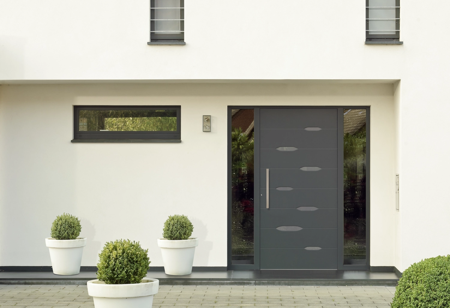 Montage Mündlein - Bauen und Renovieren - Braune Holzeingangstür eines weißen Südseitenhauses
