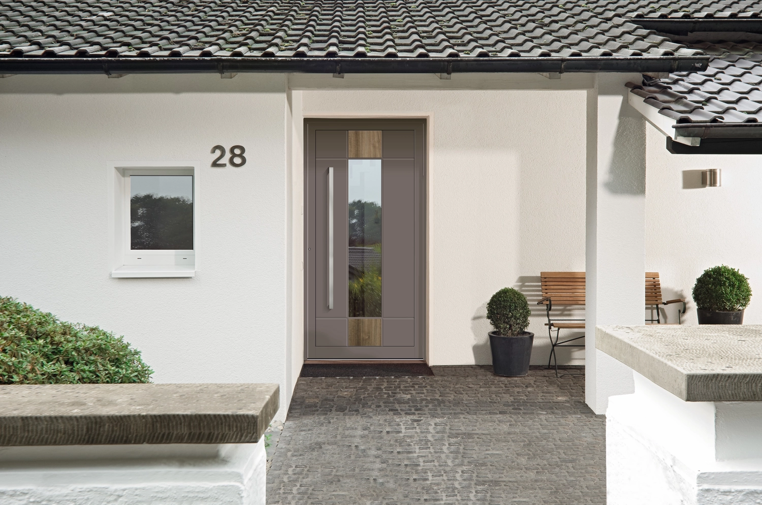 Montage Mündlein – Bauen und Renovieren – Eingangstür aus Glas zu einem großen Apartmenthotel. Die Materialien sind Holz und Stahl, die Einrichtung ist geschmackvoll.